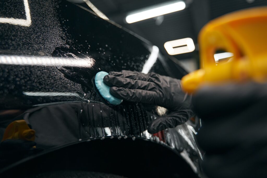 Auto detailing professional preparing automobile for polishing