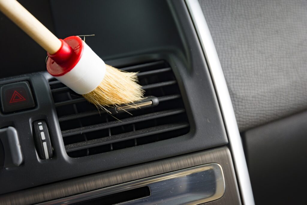 Die Klimaanlage eines Autos wird mit einem Pinsel gesäubert